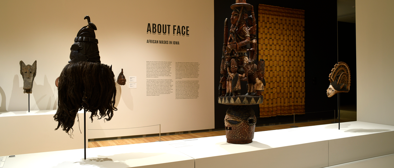 An installation shot of "About Face," featuring a few African masks.