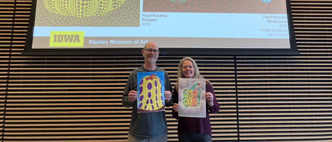two adults standing in front of examples of Kusama's 