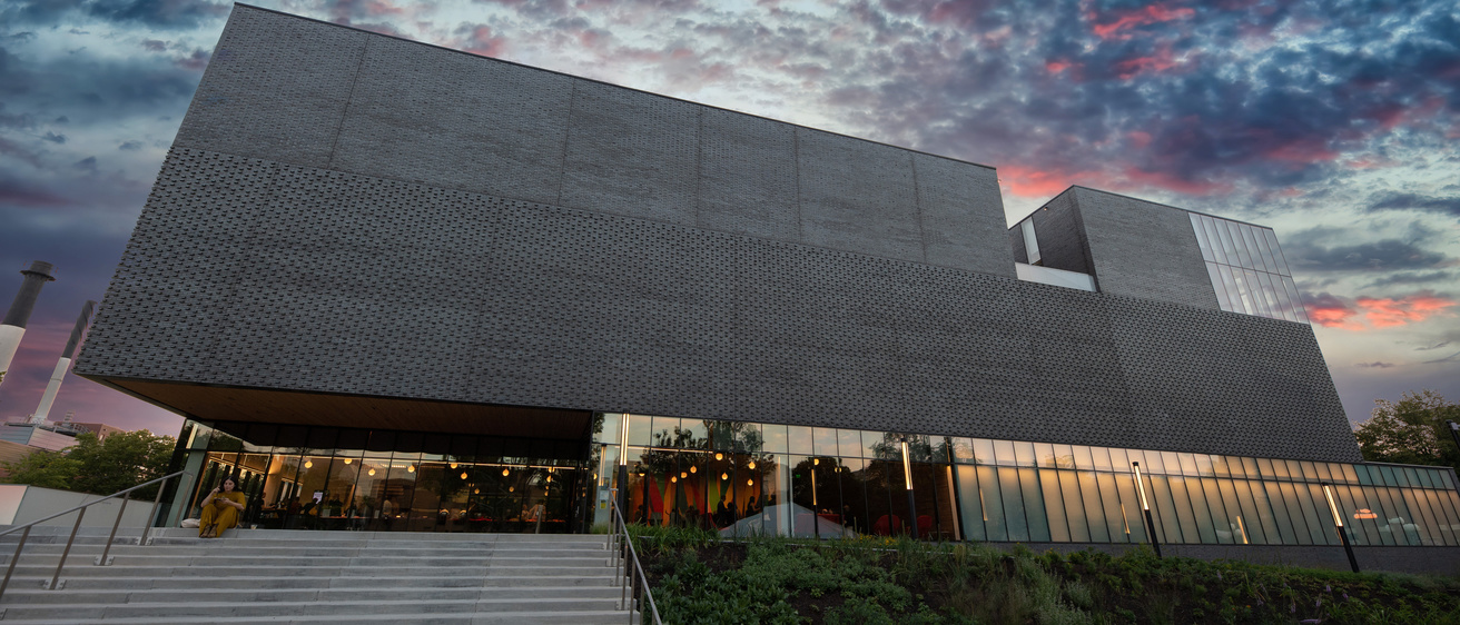 A dark grey building against an evening sky