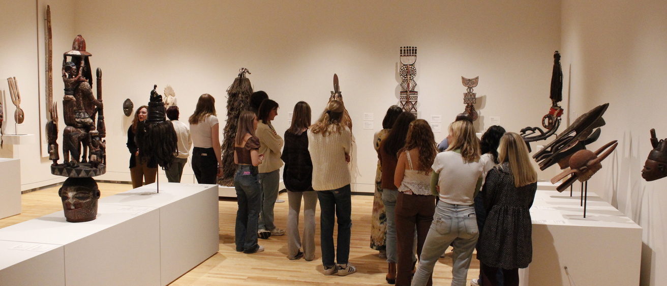 A group of people standing in a gallery viewing art