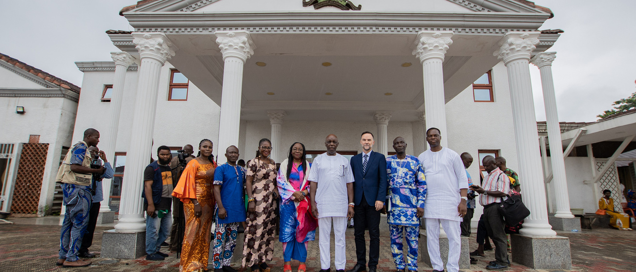 A group of people standing in front of a white palatial building