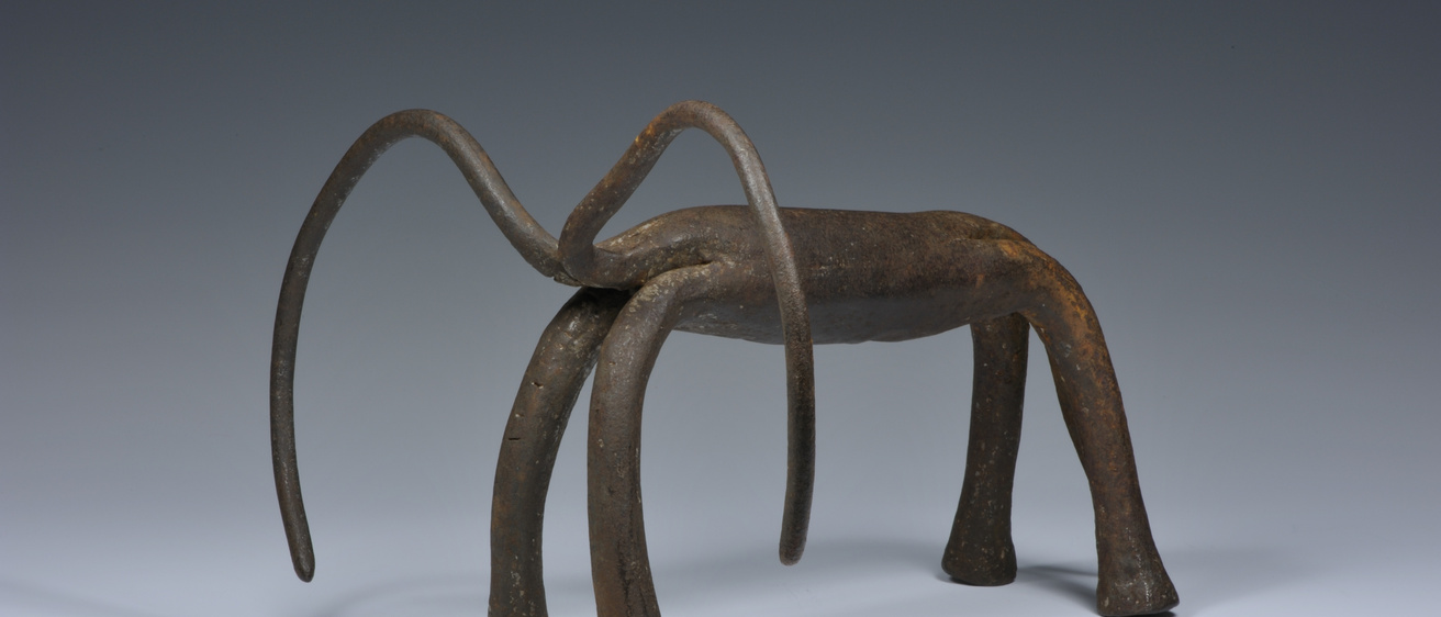 Iron sculpture depicting a four-legged animal with long, curving horns
