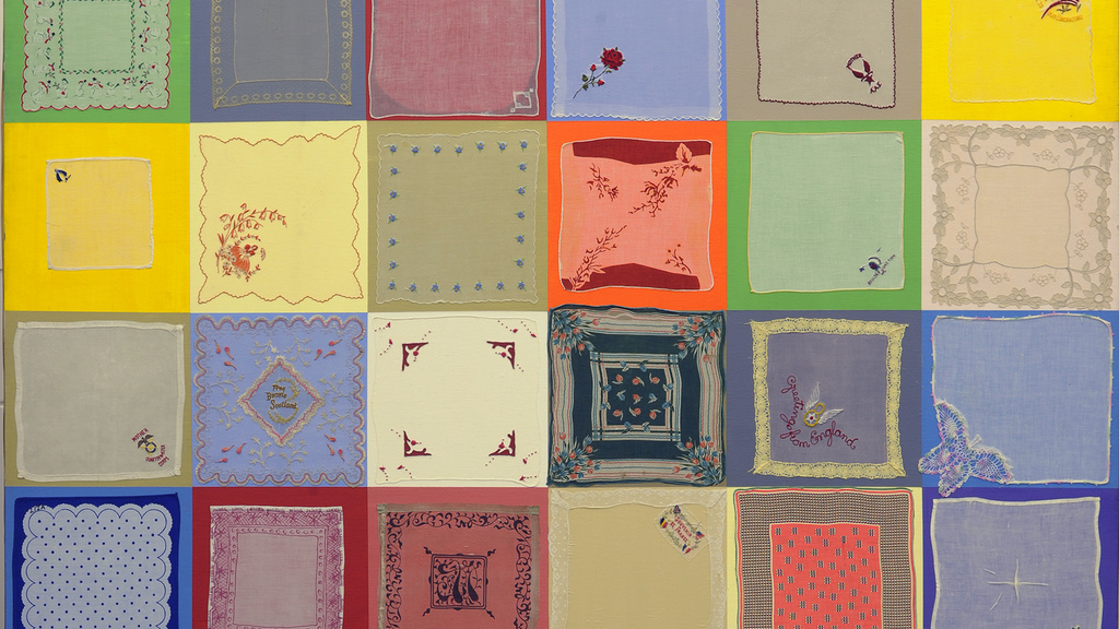 36 small squares painted different colors, with a handkerchief over each square, resembling a quilt.