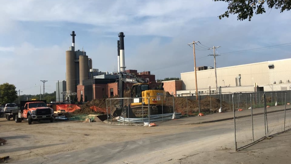 Empty construction site with UI power plant smoke stacks in the background