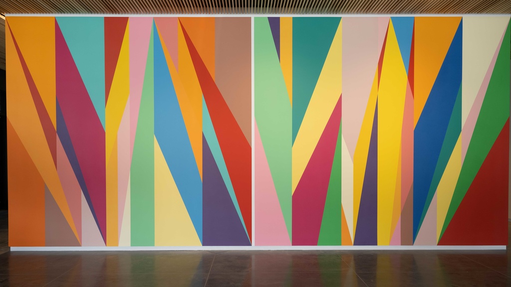 A wall painted with brightly colored geometric shapes. Each shape has a unique color.