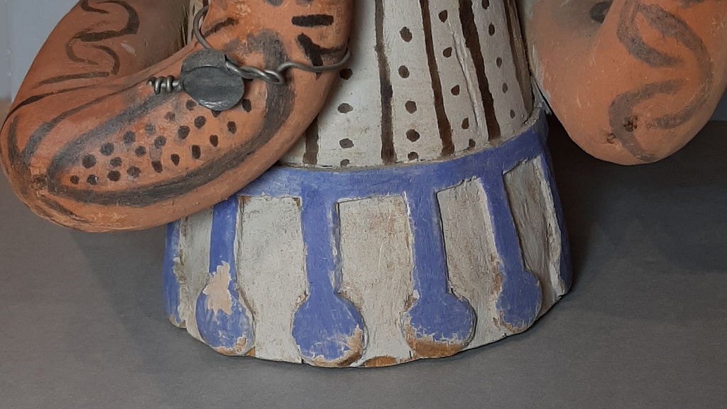 Base of Mami Wata figure showing decorations with flaking and missing blue paint.