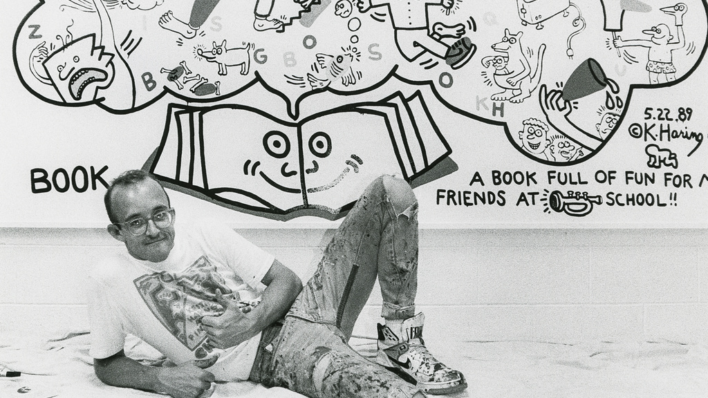Keith Haring posing with his mural at Horn Elementary School