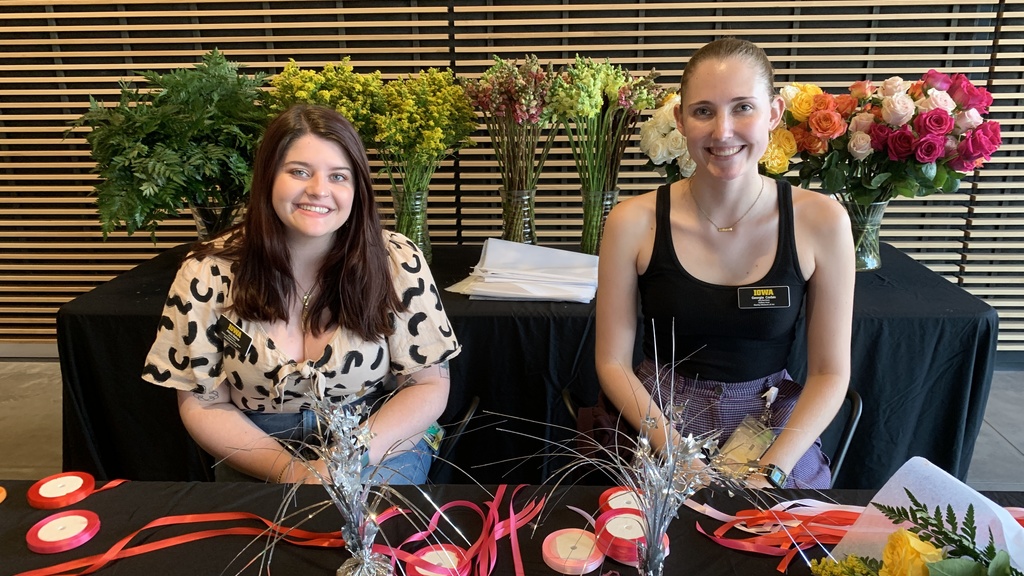 two students working at the flower station. Alexis Belme the campus engagement coordinator is one the left and Georgia Corbin a gallery host is one the right 
