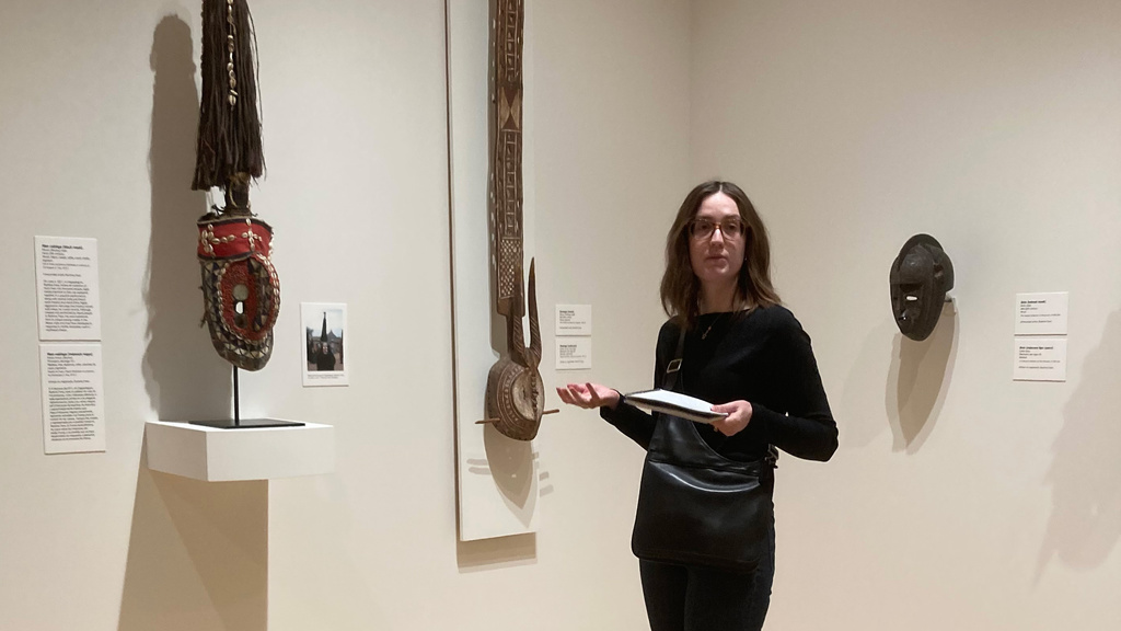 A photo of Amelia Goldsby standing and presenting in one of the African art galleries at the Stanley Museum of Art.