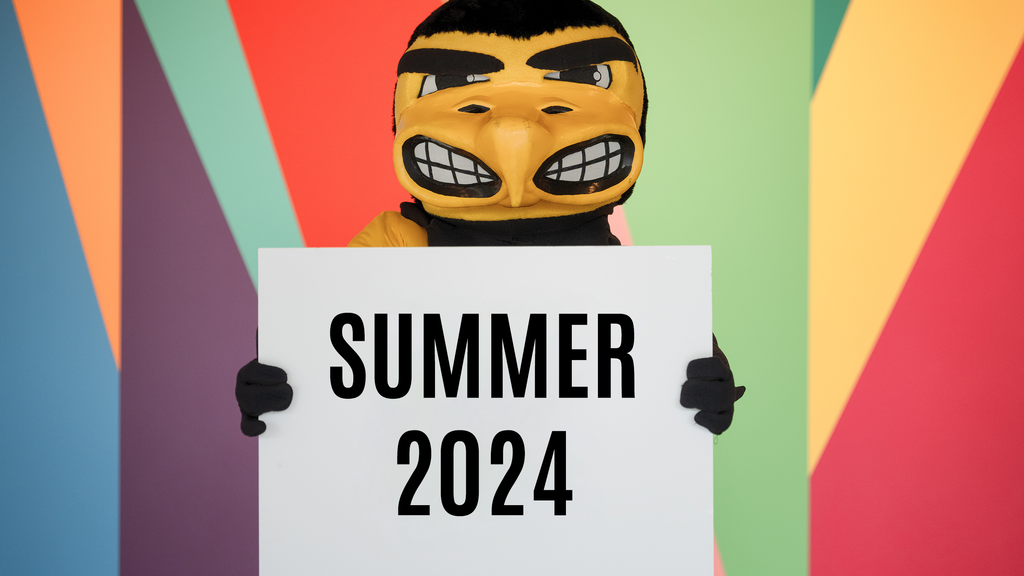 Herky mascot holding up a sign that reads "Summer 2024"