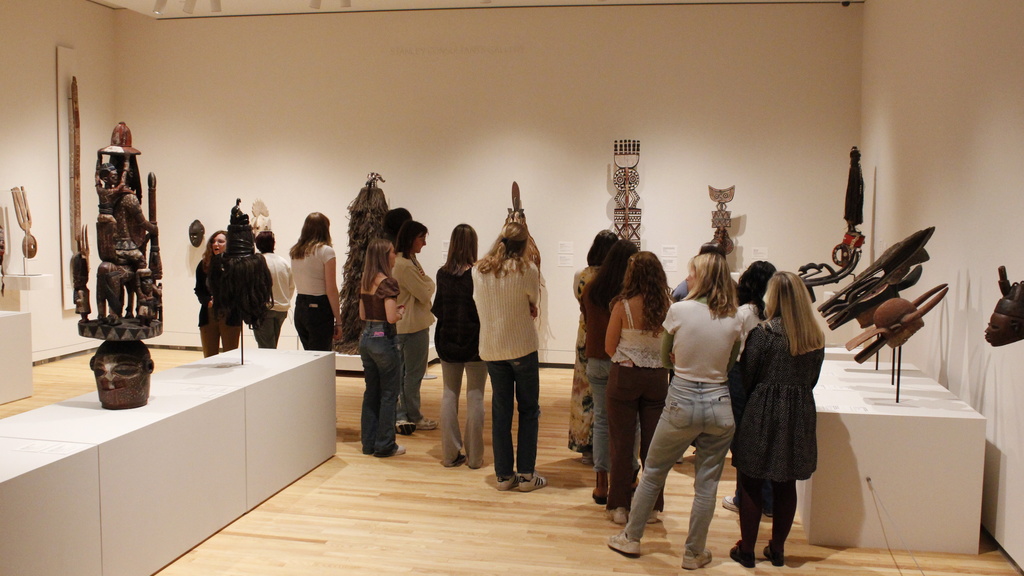 A group of people standing in a gallery viewing art
