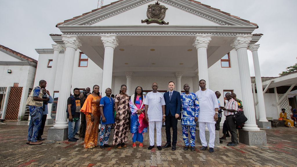 A group of people standing in front of a white palatial building