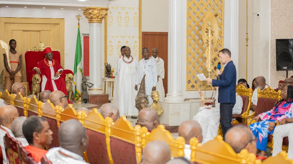 A court full of seated officials looking at a person in a suit speaking into a mic
