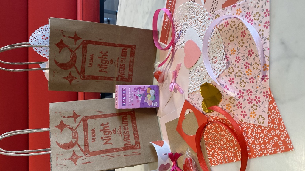 A photo of two valentine's craft bags and their contents: candies, blank valentines, ribbons, stickers, and more.