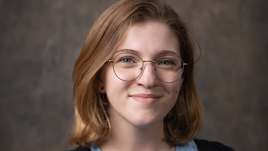 A photo of Katharine with a grey background. 