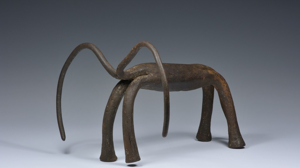 Iron sculpture depicting a four-legged animal with long, curving horns