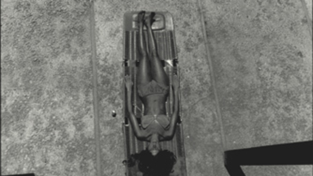 woman lying on a lounge chair seen from above on the deck of a swimming pool