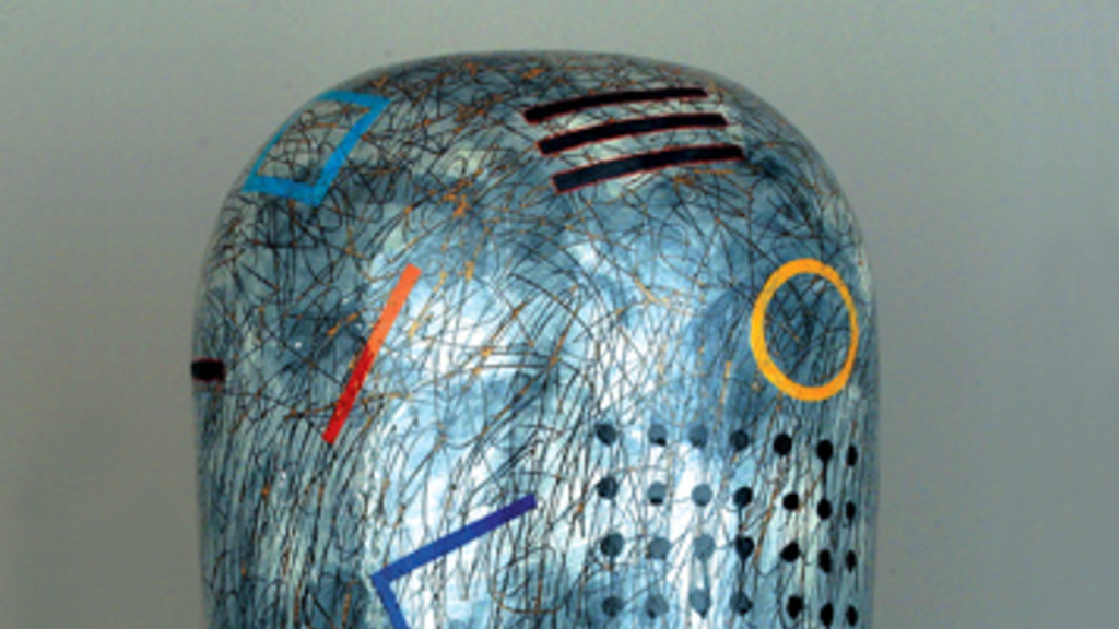 Pill-shaped sculpture covered in dripping white glaze, abstract shapes in primary colors, black lines and dots, and black scribbles.