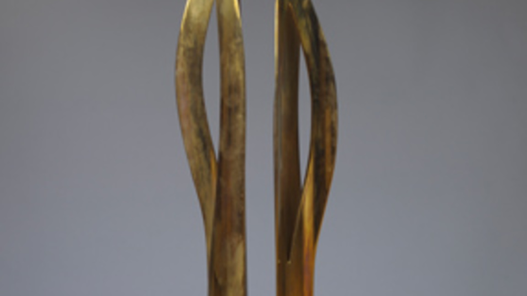 A bronze sculpture composed of two grass-like pieces that reach upward. The pieces each split towards the middle, bow apart, and come back together at the top, with the tips reaching away.